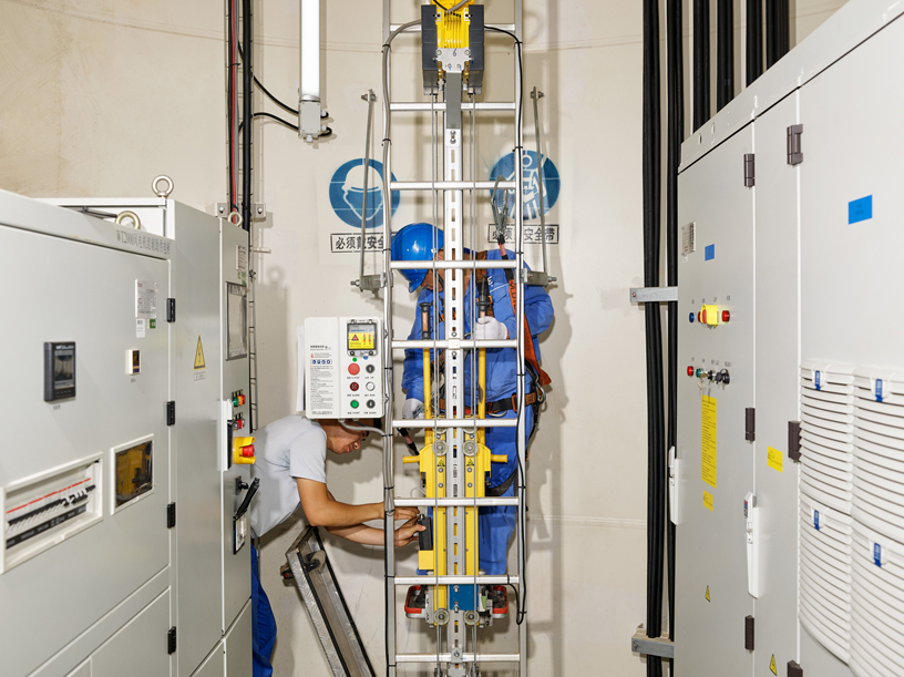 A maintenance worker prepares to ascend a wind turbine.