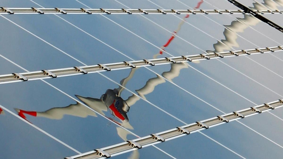 A power-generating wind turbine is reflected in solar panels. The Trump administration extended tax breaks for both solar and wind projects on Thursday. Reuters